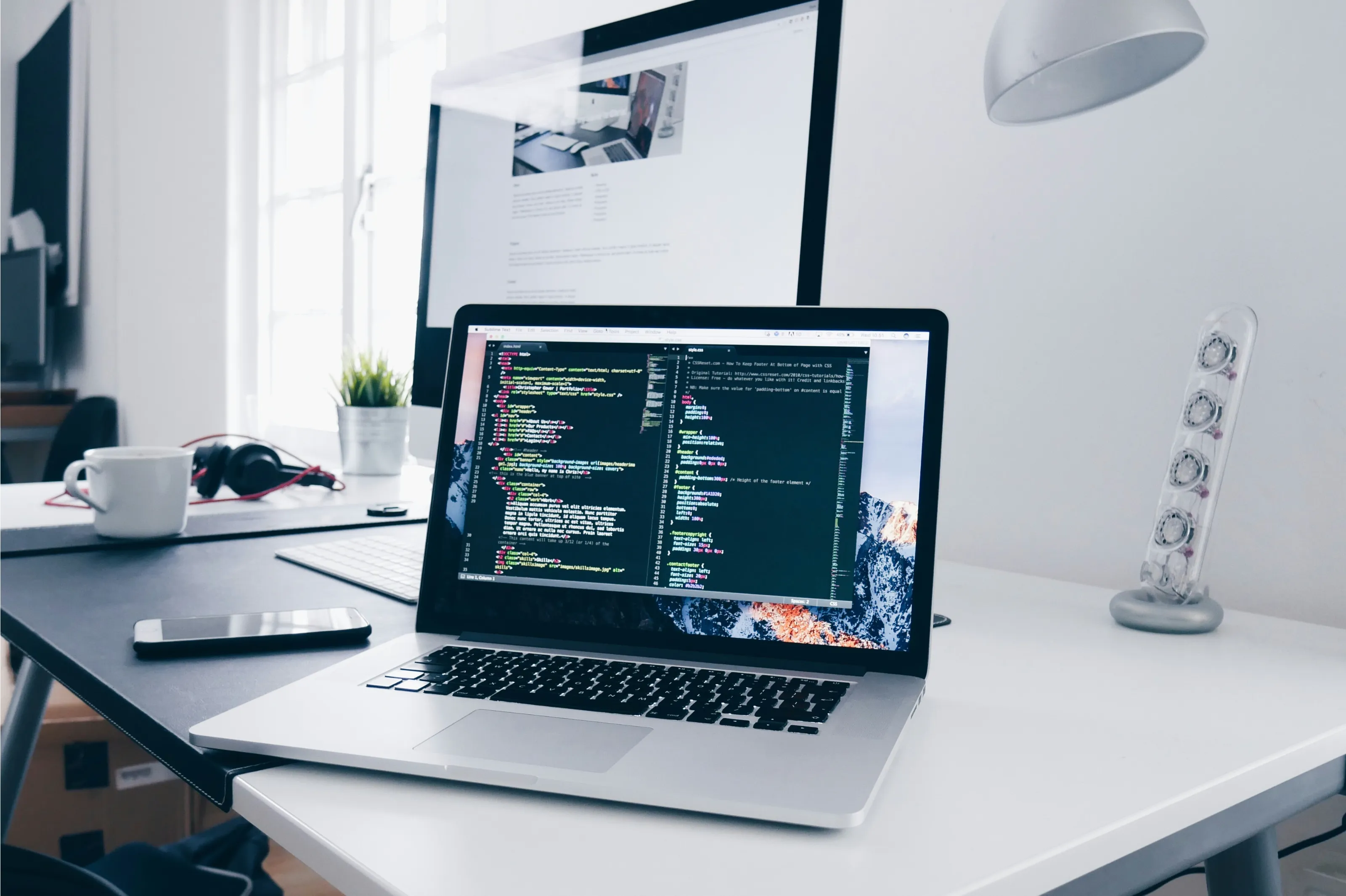 A naturally lit software workspace with source code on a laptop