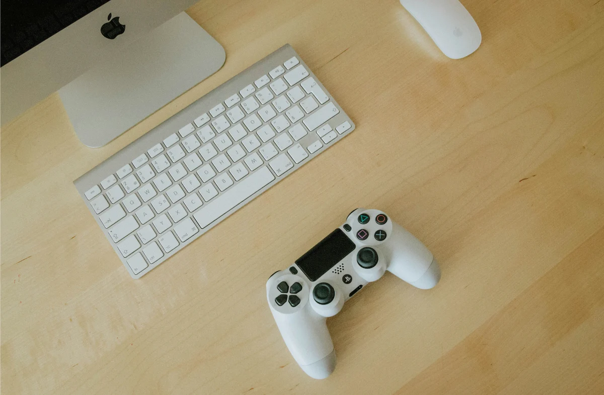 White controller and keyboard on a light wooden desk